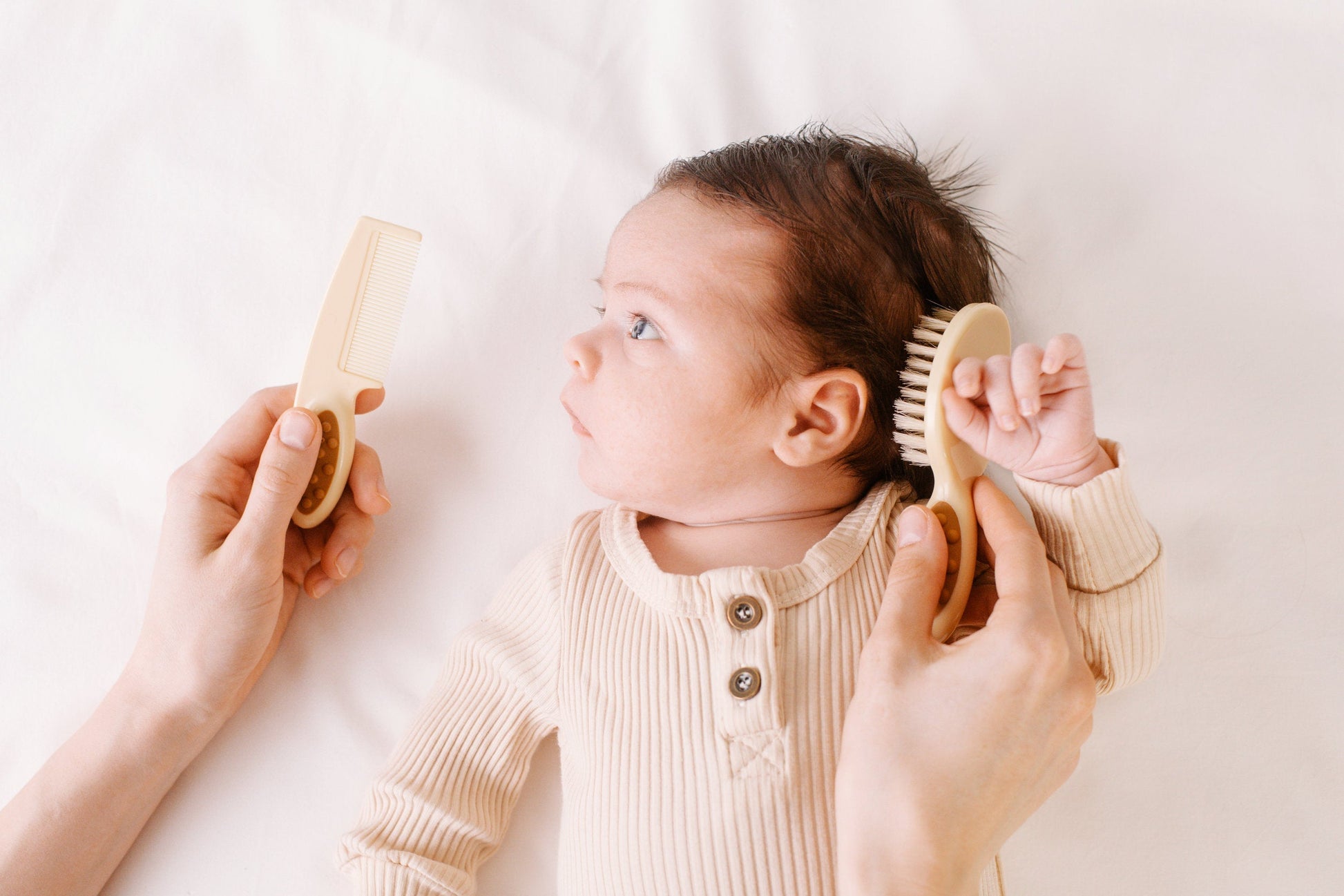 Mother brushing infant's hair